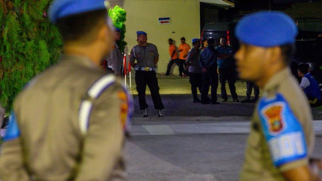 Sejumlah polisi berjaga di depan kamar jenazah tempat disemayamkannya jenazah Bharatu Moh Syaiful Muhdori di Rumah Sakit Bhayangkara Palu, Sulawesi Tengah, Jumat (13/12) malam. [ANTARA FOTO/Basri Marzuki]