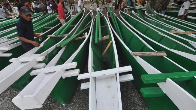 Nelayan mengamati perahu bantuan yang akan dibagikan kepada mereka di Kelurahan Tipo, Kecamatan Ulujadi, Palu, Sulawesi Tengah, Sabtu (14/12). [ANTARA FOTO/Mohamad Hamzah]