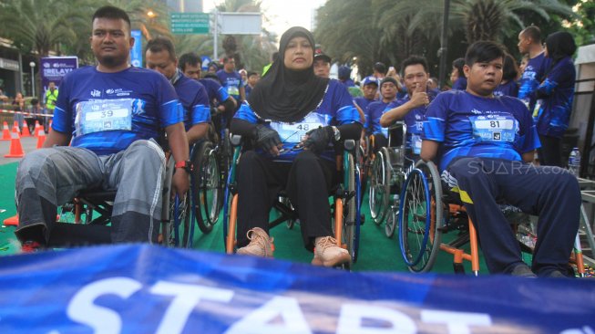 Peserta lari Disabilitas mengikuti BPJAMSOSTEK Relay Marathon 2019 di Epicentrum, Kuningan, Jakarta, Minggu (15/12). [Suara.com/Oke Atmaja]
