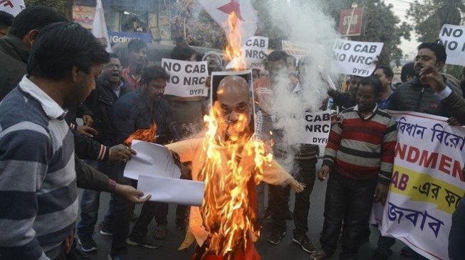 Para pemrotes membakar gambar Menteri Dalam Negeri India Amit Shah sebagai bentuk protes atas pengesahan UU Kewarganegaraan baru yang dinilai anti-Muslim. (Foto: AFP)
