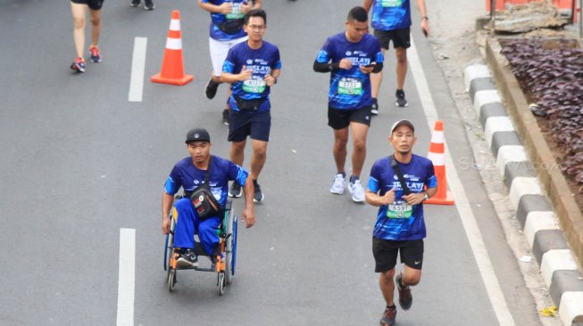 Peserta lari Disabilitas mengikuti BPJAMSOSTEK Relay Marathon 2019 di Epicentrum, Kuningan, Jakarta, Minggu (15/12). [Suara.com/Oke Atmaja]
