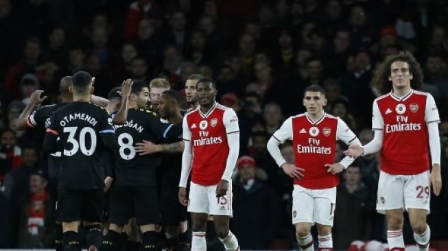 Para pemain Arsenal tertunduk lesu usai dikalahkan Manchester City 0-3. (IAN KINGTON / IKIMAGES / AFP)