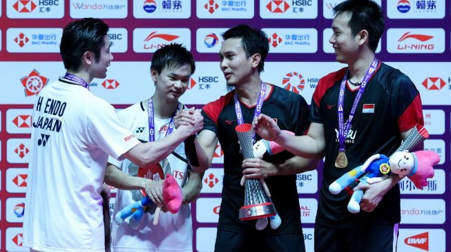 Pasangan ganda putra Indonesia, Hendra Setiawan/Mohammad Ahsan, menyalami Hiroyuki Endo/Yuta Watanabe (Jepang) usai menjuarai BWF World Tour Finals (WTF) 2019, Minggu (15/12) malam WIB. [Humas PBSI]