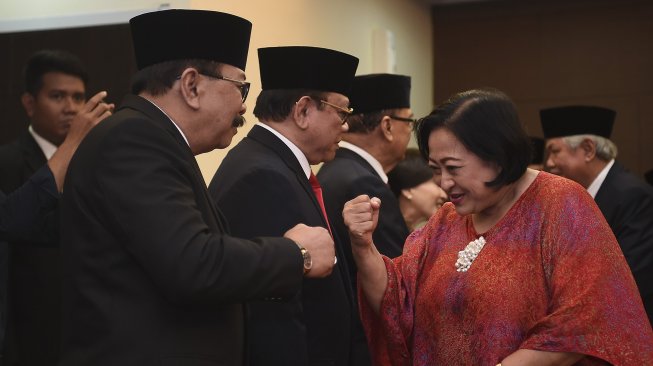 Ketua Dewan Pertimbangan Presiden (Wantimpres) periode 2015-2019 Sri Adiningsih (kanan) memberikan ucapan selamat kepada anggota Watimpres periode 2019-2024 Soekarwo (kiri) usai serah terima jabatan ketua dan anggota Wantimpres periode 2015-2019 kepada ketua dan anggota Wantimpres periode 2019-2024 di Jakarta, Senin (16/12). [ANTARA FOTO/Nova Wahyudi]