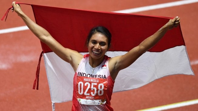 Atlet lompat jauh Indonesia Maria Natalia Londa membentangkan Bendera Merah Putih setelah berhasil memenangkan pertandingan Final Lompat Jauh Putri SEA Games ke-30 di Stadion Atletik New Clark, Filipina, Minggu (8/12/2019). [ANTARA FOTO/Nyoman Budhiana]