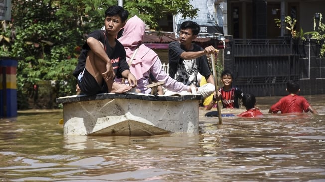 Warga melintasi banjir di Dayeuhkolot, Kabupaten Bandung, Jawa Barat, Rabu (18/12). [ANTARA FOTO/Novrian Arbi]
