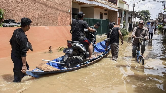 Warga melintasi banjir di Dayeuhkolot, Kabupaten Bandung, Jawa Barat, Rabu (18/12). [ANTARA FOTO/Novrian Arbi]
