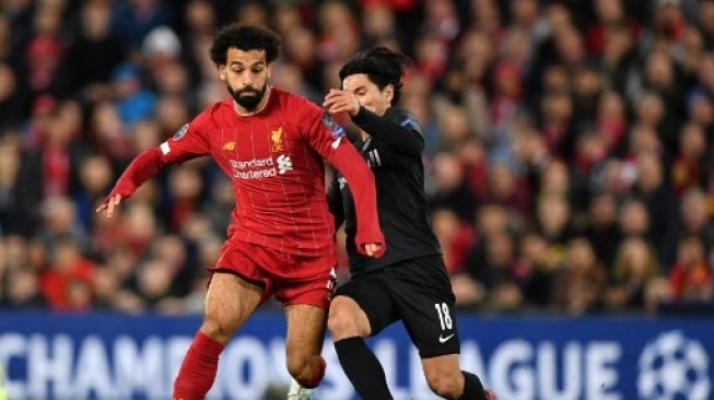 Pemain Salzburg asal Jepang Takumi Minamino berebut bola dengan pemain Liverpool Mohamed Salah di fase grup Liga Champions yang digelar di Anfield pada 22 Oktober 2019. [AFP]