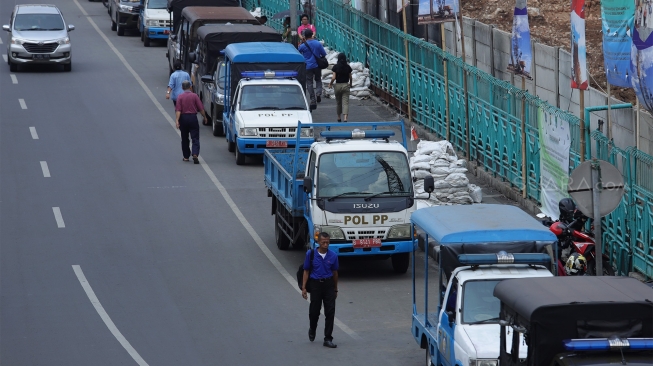 Personel Satuan Polisi Pamong Praja (Satpol PP) berjaga di trotoar Jalan Stasiun Pasar Senen, Jakarta Pusat, Rabu (18/12). [Suara.com/Angga Budhiyanto]