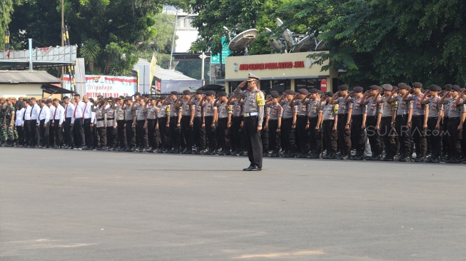 Anggota kepolisian dan TNI mengikuti apel gabungan operasi Lilin Jaya 2019 di Lapangan Promoter Ditlantas Polda Metro Jaya, Kamis (19/12).  [Suara.com/Alfian Winanto]
