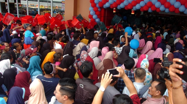 Calon pembeli berebut masuk ke dalam salah satu tempat perbelanjaan yang menawarkan diskon akhir tahun di Desa Singkil, Kabupaten Tegal, Jawa Tengah, Kamis (19/12). [ANTARA FOTO/Oky Lukmansyah]