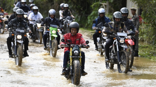 Presiden Joko Widodo (Jokowi) mengendarai motor chopper hasil modifikasi Kawasaki WR175 saat melintas di jalan Trans Kalimantan, Kecamatan Krayan, Kabupaten Nunukan, Kalimantan Utara, Kamis (19/12/2019). [Antara/Puspa Perwitasari]