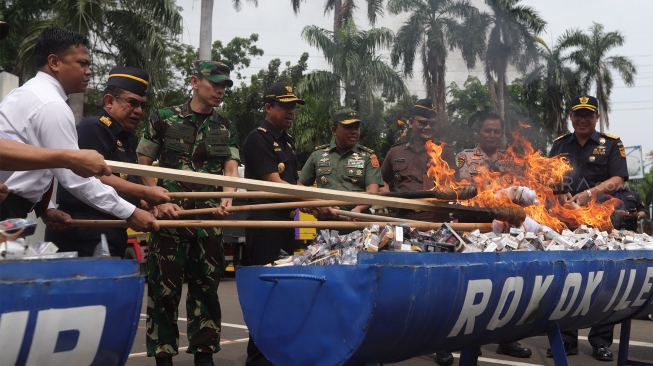 Direktur Jenderal Bea dan Cukai Kementerian Keuangan Heru Pambudi (keempat kiri) memusnahkan barang bukti rokok ilegal di Kantor Bea Cukai, Rawamangun, Jakarta, Kamis (19/12). [Suara.com/Angga Budhiyanto]

