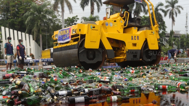 Petugas gunakan alat berat memusnahkan barang bukti minuman keras di Kantor Bea Cukai, Rawamangun, Jakarta, Kamis, (19/12). [Suara.com/Angga Budhiyanto]