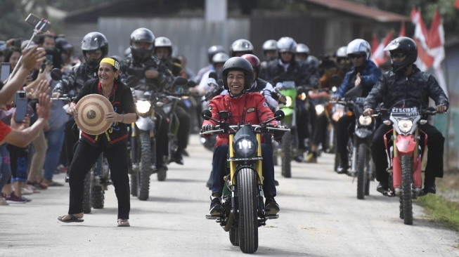 Presiden Joko Widodo (Jokowi) mengendarai motor chopper hasil modifikasi Kawasaki WR175 saat melintas di jalan Trans Kalimantan, Kecamatan Krayan, Kabupaten Nunukan, Kalimantan Utara, Kamis (19/12/2019). [Antara/Puspa Perwitasari]