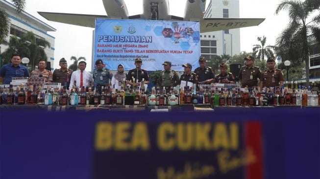 Direktur Jenderal Bea dan Cukai Kementerian Keuangan Heru Pambudi (tengah) memberikan keterangan kepada wartawan saat pemusnahan barang bukti minuman keras di Kantor Bea Cukai, Rawamangun, Jakarta, Kamis (19/12).  [Suara.com/Angga Budhiyanto]
