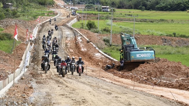 Presiden Joko Widodo mengendarai motor Copper melintasi jalan Trans Kalimantan di Kecamatan Krayan, Kabupaten Nunukan, Kalimantan Utara, Kamis (19/12). [ANTARA FOTO/Puspa Perwitasari]