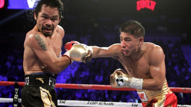 Jessie Vargas (kanan) mendaratkan pukulan ke wajah ikon tinju dunia Manny Pacquiao dalam pertarungan di Thomas & Mack Center, Las Vegas, AS, Sabtu (6/11/2016). [AFP/John Gurzinski]