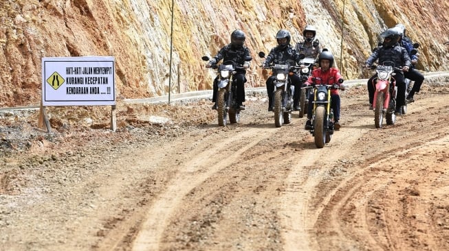 Presiden Joko Widodo mengendarai motor Copper melintasi jalan Trans Kalimantan di Kecamatan Krayan, Kabupaten Nunukan, Kalimantan Utara, Kamis (19/12). [ANTARA FOTO/Puspa Perwitasari]