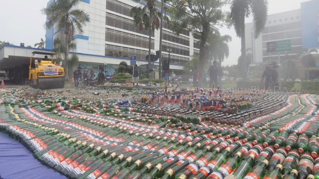 Petugas gunakan alat berat memusnahkan barang bukti minuman keras di Kantor Bea Cukai, Rawamangun, Jakarta, Kamis, (19/12). [Suara.com/Angga Budhiyanto]