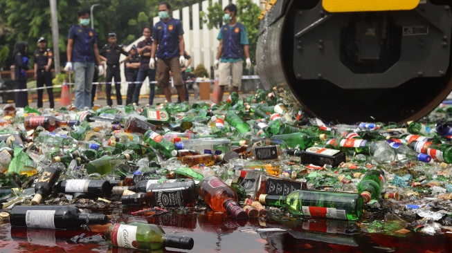 Petugas gunakan alat berat memusnahkan barang bukti minuman keras di Kantor Bea Cukai, Rawamangun, Jakarta, Kamis, (19/12). [Suara.com/Angga Budhiyanto]