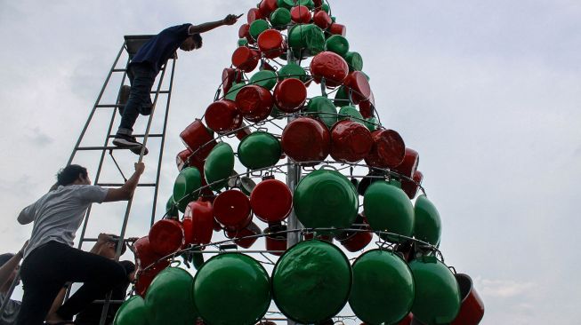 Pemuda menata pernak pernik pohon Natal yang terbuat dari alat rumah tangga di Gereja Katolik St. Maria Annuntiata Sidoarjo, Jawa Timur, Kamis (19/12). [ANTARA FOTO/Umarul Faruq]