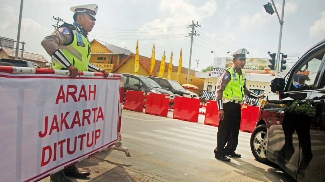 Polisi memberhentikan kendaraan ke arah Jakarta di pintu keluar tol Adiwerna, Kabupaten Tegal, Jawa Tengah, Sabtu (21/12). [ANTARA FOTO/Oky Lukmansyah]