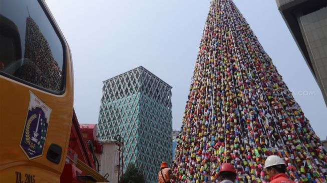 Petugas PPSU menata pohon Natal dari miniatur ondel-ondel yang terbuat dari botol minuman bekas di Food Court Thamrin 10, kawasan Thamrin, Jakarta, Sabtu (21/12). [Suara.com/Angga Budhiyanto]