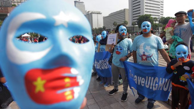 Sejumlah warga melakukan aksi mengecam tindakan kekerasan pemerintah Cina terhadap muslim Uighur di kawasan Bundaran Hotel Indonesia, Jakarta, Minggu (22/12). [ANTARA FOTO/Reno Esnir]
