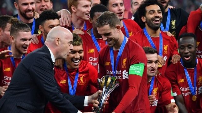 Kapten Liverpool, Jordan Henderson, menerima trofi Piala Dunia Antarklub 2019 dari Presiden FIFA, Gianni Infantino. (GIUSEPPE CACACE / AFP)