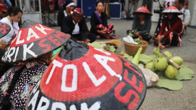 Massa aksi yang tergabung dalam Aliansi Perempuan Bangkit Menggugat berunjuk rasa di kawasan Monas, Jakarta, Minggu (22/12). [Suara.com/Alfian Winanto]
