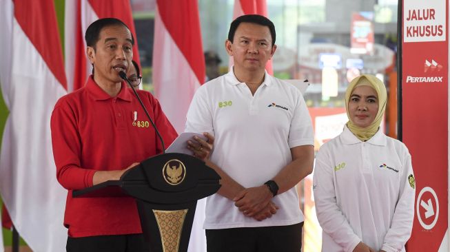 Presiden Joko Widodo (kiri) didampingi Direktur Utama Pertamina Nicke Widyawati (kanan) dan Komisaris Utama Pertamina Basuki Tjahaja Purnama (tengah) memberikan sambutan saat peresmian implementasi program Biodiesel 30 persen (B30) di SPBU Pertamina MT Haryono, Jakarta, Senin (23/12).[ANTARA FOTO/Hafidz Mubarak]
