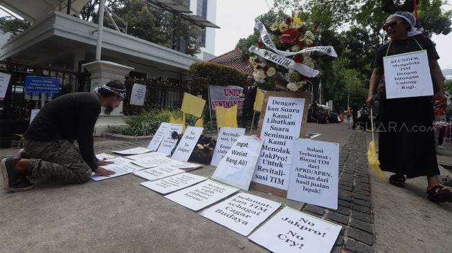 Sejumlah seniman yang tergabung dalam Forum Seniman Peduli Peduli TIM melakukan silent action atau akasi senyap di depann Balai Kota DKI Jakarta, Senin (23/12).  [Suara.com/Angga Budhiyanto]