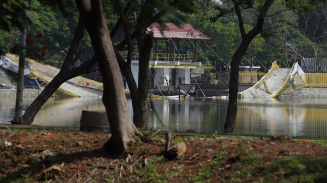 Jembatan lengkung yang roboh di hutan kota Kemayoran, Jakarta Pusat, Senin (23/12). [Suara.com/Angga Budiyanto]