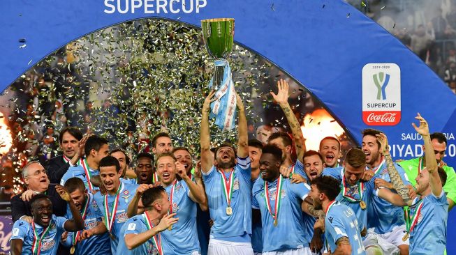 Pemain Lazio mengangkat trofi setelah pertandingan final sepakbola Supercoppa Italia antara Juventus melawan Lazio di Stadion King Saud University, Riyadh, Senin (23/12) dini hari WIB. [GIUSEPPE CACACE / AFP]