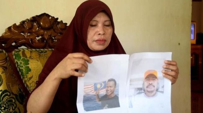 Wa Daya, istri dari seorang korban sandera Abu Sayyaf memperlihatkan foto suaminya, Maharudin Lunani (48) dan keponakannya, Samiun Maneu (27) yang kini disandera kelompok Abu Sayyaf (Istimewa/zonautara.com)