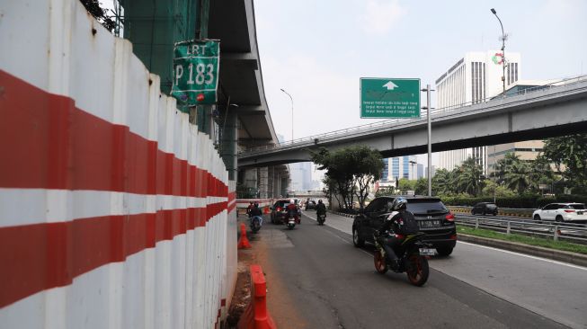 Plang ganjil-genap yang berada di ruas Jalan Kuningan, Jakarta, Selasa (24/12). [Suara.com/Alfian Winanto]