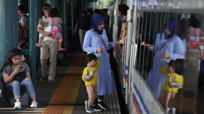 Calon penumpang bergegas memasuki rangkaian kereta api di Stasiun Gambir, Jakarta Pusat, Senin (23/12). [Suara.com/Angga Budhiyanto]