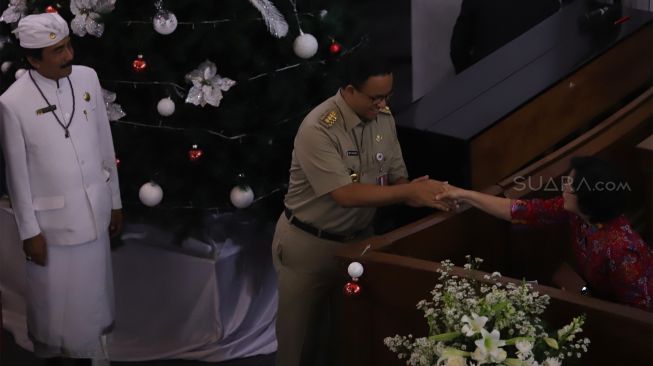 Gubernur DKI Jakarta Anies Baswedan (tengah) bersalaman dengan seorang Jemaat saat misa malam Natal di GPIB Immannuel, Gambir, Jakarta Pusat, Selasa(24/12). [Suara.com/Angga Budhiyanto]