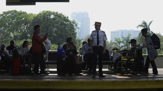 Sejumlah calon penumpang menunggu kedatangan kereta api di Stasiun Gambir, Jakarta Pusat, Senin (23/12). [Suara.com/Angga Budhiyanto] 