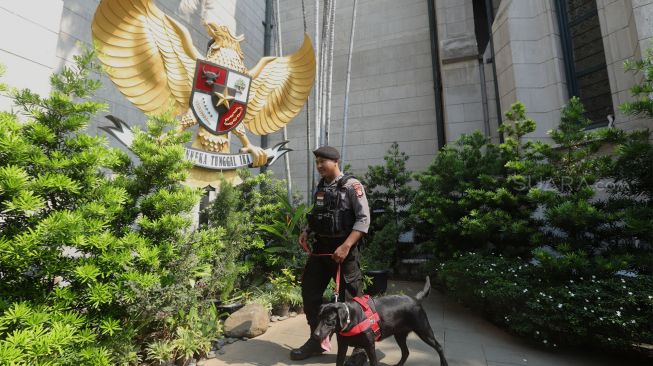 Tim Gegana menggunakan anjing pelacak menyisir kawasan Gereja Katedral Jakarta, Selasa (24/12). [Suara.com/Angga Budhiyanto]