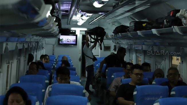 Sejumlah penumpang memasuki rangkaian kereta api di Stasiun Gambir, Jakarta Pusat, Senin (23/12). [Suara.com/Angga Budhiyanto]  
