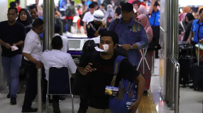 Sejumlah calon penumpang memadati Stasiun Gambir, Jakarta Pusat, Senin (23/12). [Suara.com/Angga Budhiyanto]  