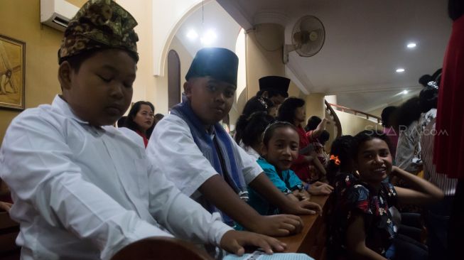 Para jamaat cilik saat mengikuti proses misa natal khusu anak-anak di Gereja Santo Servatius, Kampung Sawah, Bekasi, Rabu (25/12). (Suara.com/Alfian Winanto)