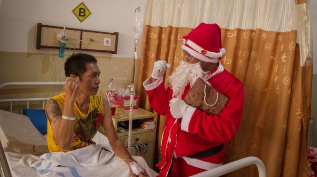 Karyawan rumah sakit mengenakan kostum sinterklas mengunjungi pasien saat Perayaan Natal di Rumah Sakit Brayat Minulya, Solo, Jawa Tengah, Rabu (25/12).[ANTARA FOTO/Mohammad Ayudha]