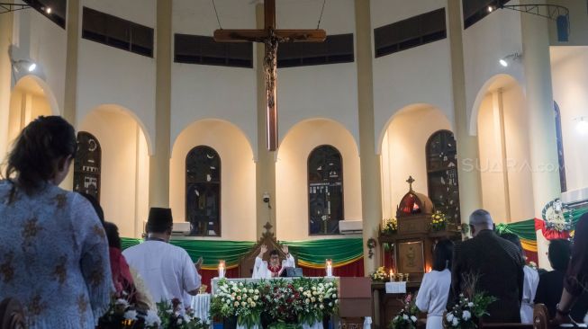 Jamaat gereja yang sedang khusyuk mengikuti prosesi misa malam natal di Gereja Santo Servatius Kampung Sawah, Bekasi Jawa Barat, Selasa (24/12) malam.