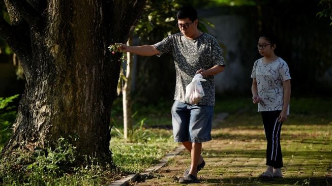 Korban selamat Fikramullah berdoa saat memperingati 15 tahun musibah gempa dan tsunami di kuburan Massal Siron, Aceh, Kamis (26/12). [CHAIDEER MAHYUDDIN / AFP]