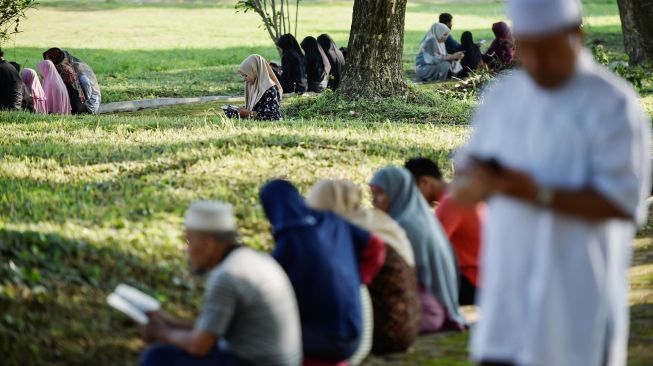 Warga berdoa saat memperingati 15 tahun musibah gempa dan tsunami di kuburan Massal Siron, Aceh, Kamis (26/12). [CHAIDEER MAHYUDDIN / AFP]
