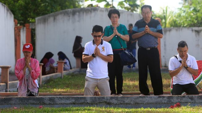 Sejumlah umat muslim bersama warga keturunan Tionghoa melaksanakan doa bersama saat berziarah ke kuburan massal korban gempa dan gelombang tsunami di Desa Suak Indrapuri, Johan Pahlawan, Aceh Barat, Aceh, Kamis (26/12). [ANTARA FOTO/Syifa Yulinnas]