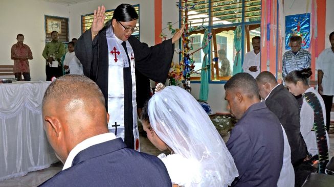 Pendeta Paulina mendoakan empat pasangan suami istri di Gereja Kristen Indonesia (GKI) Eden Tindaret, Yapen Utara, Kepulauan Yapen, Papua, Kamis (26/12). [ANTARA FOTO/Indrayadi TH]